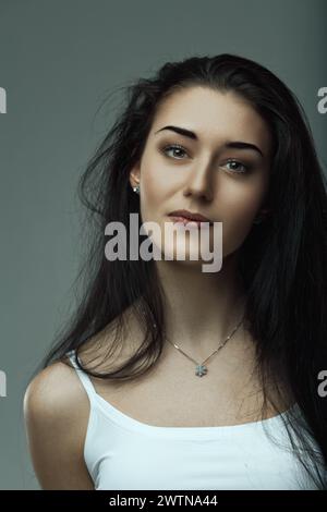 Una giovane donna con occhi perspicaci irradia tranquillità e fascino Foto Stock