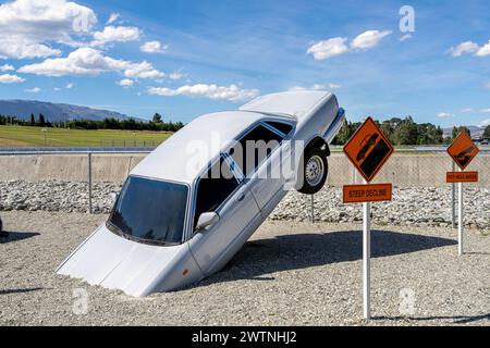 Cromwell, nuova Zelanda- 3 gennaio 2024: Installazione di Silver car art apparentemente immersa nella ghiaia, esposta a Highlands Park, Cromwell, con 'ripido Foto Stock