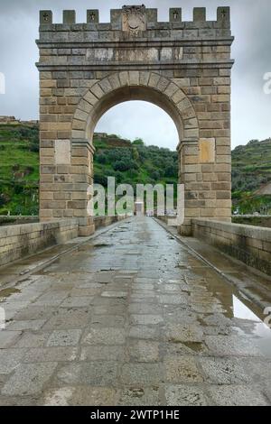 Arco di trionfo del Ponte di Traiano ad Alcantara, ponte ad arco in pietra romano, piccolo tempio romano sulla riva sinistra sullo sfondo, Caceres, Spagna Foto Stock