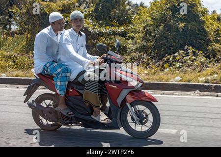 YALA, THAILANDIA, Mar 01 2024, due giovani uomini in abbigliamento tradizionale guidano una moto Foto Stock