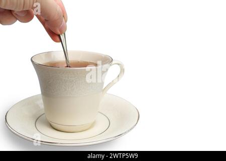Mescolare una tazza di tè con un cucchiaio su sfondo bianco Foto Stock
