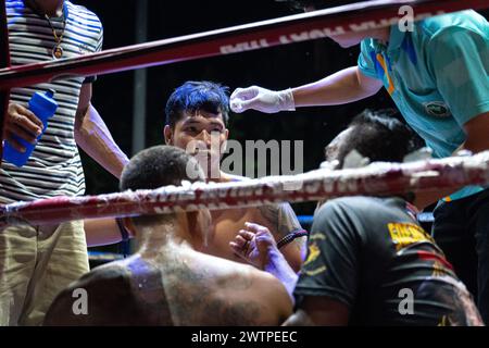 Il pugile vincitore Frame Payak (C) viene visto parlare con l'organizzatore mentre riceve un trattamento, durante i combattimenti Muay Thai, sull'isola di Koh Chang, Thailandia. Foto Stock