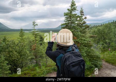 Vista sulla valle dei diecimila fumosi. Donna che scatta foto con lo smartphone. Parco nazionale e riserva naturale di Katmai. Alaska. STATI UNITI. Foto Stock