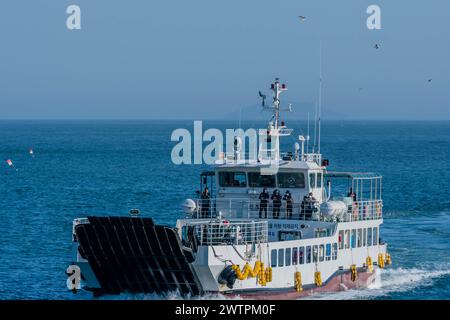 Un traghetto che naviga sulle acque blu lasciandosi dietro una scia bianca, a Sinjin-Do, Corea del Sud, Asia Foto Stock