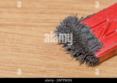 Magnete rosso che attrae limature di ferro, illustrando un campo magnetico in un contesto scientifico Foto Stock