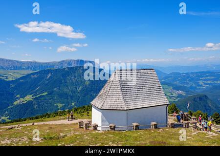 Cappella della Croce Santa a Resciesa nelle dolomiti, montagna con escursionisti una giornata estiva di sole e una vista panoramica, Ortisei, Val gardena, Italia, Europ Foto Stock