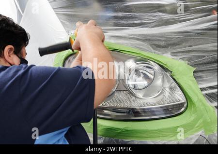 Mechanic la mano di lucidatura è la vettura del faro. Foto Stock