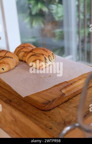 Focalizzata su croissant appena sfornati su un tavolo di legno. Concetto di alimentazione sana e dolce. Deliziosa colazione francese Foto Stock