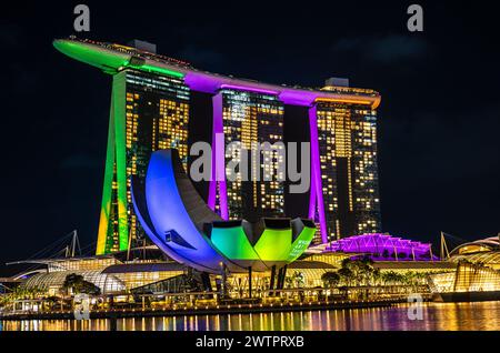 Singapore, 24 gennaio 2024: Hotel Marina Bay Sands a Singapore di luce notturna, la sua illuminazione luminosa riflessa nelle acque. Museo ArtScience e. Foto Stock