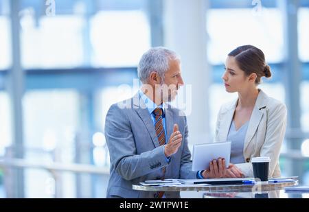 Uomini d'affari, colleghi e conversazione con tablet, conversazione e discussione per il workshop. Chat, gesti delle mani e colleghi per una conferenza Foto Stock