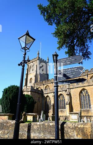 Vista della chiesa di tutti i Santi lungo Church Street con un cartello e un lampione in primo piano, Martock, Somerset, Regno Unito, Europa. Foto Stock