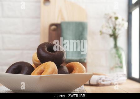 Immagine orizzontale di un piatto di ciambelle con lo sfondo fuori fuoco di una parete e di una finestra della cucina. Foto Stock