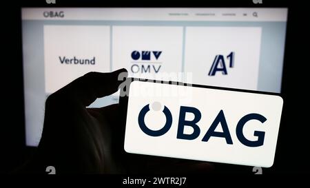 Persona che detiene uno smartphone con il logo della società austriaca Österreichische Beteiligungs AG (ÖBAG) davanti al sito web. Mettere a fuoco il display del telefono. Foto Stock