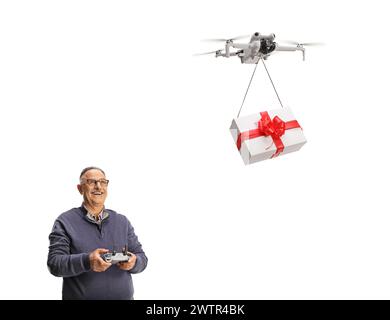 Uomo maturo felice che consegna una confezione regalo con un drone isolato su sfondo bianco Foto Stock