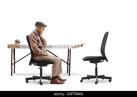 Paziente di sesso maschile anziano seduto su una sedia e in attesa di un medico isolato su sfondo bianco Foto Stock