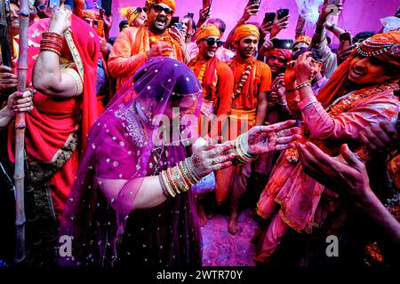 Una donna devota ha visto ballare durante il Lathmar Holi Festival come da rituale tradizionale. Il festival Lathmar Holi si basa su una leggenda indù, secondo la quale Lord Krishna viaggiò dal suo villaggio natale di Nandgaon a Barsana per prendere in giro il suo amante Radha. Radha e il suo entourage si sono offesi per le sue avances e hanno cacciato Krishna dal villaggio. Oggi la leggenda è celebrata al tempio Radha Rani di Barsana. Ogni anno, gli uomini di Nandgaon viaggiano a Barsana, dove vengono accolti da donne che brandiscono lathis (bastoni). I festeggiamenti durano più di una settimana, in cui i partecipanti lanciano il pow colorato Foto Stock