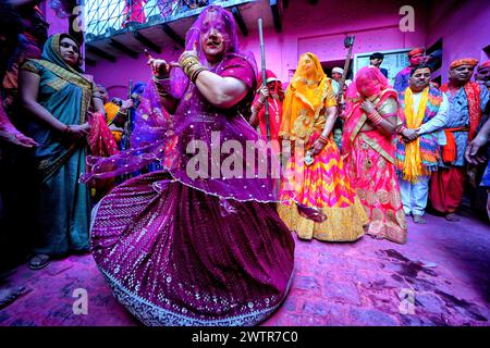 Una donna devota ha visto ballare durante il Lathmar Holi Festival con la canzone tradizionale di Lathmar Holi. Il festival Lathmar Holi si basa su una leggenda indù, secondo la quale Lord Krishna viaggiò dal suo villaggio natale di Nandgaon a Barsana per prendere in giro il suo amante Radha. Radha e il suo entourage si sono offesi per le sue avances e hanno cacciato Krishna dal villaggio. Oggi la leggenda è celebrata al tempio Radha Rani di Barsana. Ogni anno, gli uomini di Nandgaon viaggiano a Barsana, dove vengono accolti da donne che brandiscono lathis (bastoni). I festeggiamenti durano più di una settimana in cui i partecipanti lanciano Foto Stock