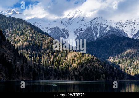 Una catena montuosa con neve sulle cime e un lago nella valle Foto Stock