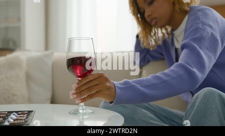 Alcolizzato donna alcolica messo bicchiere di vino rosso in tavola rifiuto dipendenza dipendenza dipendenza pensivo rilassato triste calma afroamericana ragazza a. Foto Stock