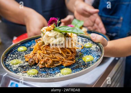 Un piatto di spaghetti con cibi assortiti Foto Stock