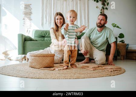 Madre e padre che giocano con il figlio in salotto a casa Foto Stock