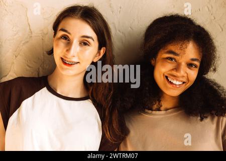 Il primo piano del ritratto di ragazze carine e felici di diverse razze sta ridendo e chattando. Gli amici simpatici sorridono e si divertono insieme. Una struttura multietnica Foto Stock