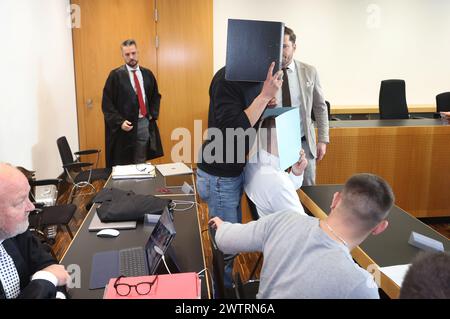 Augusta, Germania. 19 marzo 2024. L'imputato principale (centro r) siede nel molo in un'aula di tribunale insieme ad altri imputati. Sta affrontando le accuse di causare l'esplosione di un ordigno esplosivo e causare gravi danni fisici. L'11 novembre 2023, si dice che l'uomo abbia fatto esplodere un firecracker che non è permesso in Germania durante la partita di Bundesliga tra FC Augsburg e TSG 1899 Hoffenheim nel blocco visitatori. Crediti: Karl-Josef Hildenbrand/dpa/Alamy Live News Foto Stock