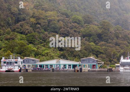 Il terminal dei traghetti all'estremità sud dello spettacolare Milford Sound a Fiordland, nuova Zelanda, uno dei luoghi più umidi del pianeta. Foto Stock