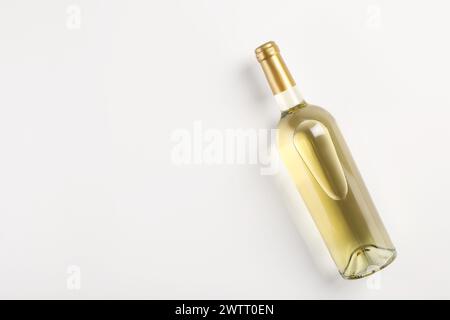 Bottiglia di vino bianco costoso su sfondo chiaro, vista dall'alto. Spazio per il testo Foto Stock