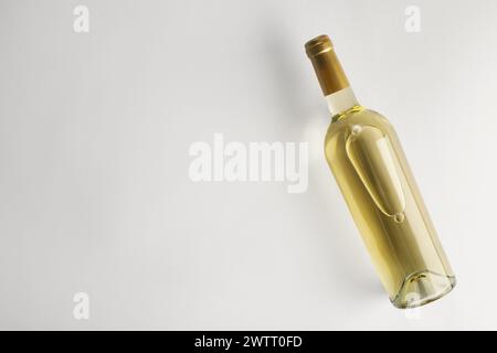 Bottiglia di vino bianco costoso su sfondo chiaro, vista dall'alto. Spazio per il testo Foto Stock