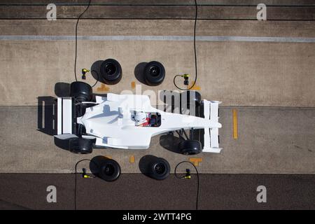 Vista aerea di un pit stop per auto da corsa con equipaggio e pilota in azione Foto Stock