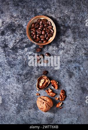 Versamenti di chicchi di caffè e noci su una superficie ruvida Foto Stock