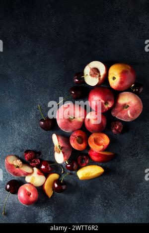 Una vivace esposizione di frutta fresca a base di pietra disposta artisticamente su uno sfondo scuro Foto Stock