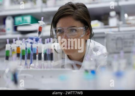 Attraente scienziata esamina la provetta di prova per i risultati Foto Stock