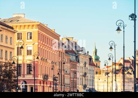 La calda luce del tramonto proietta una luce soffusa su una pittoresca fila di edifici storici europei Foto Stock