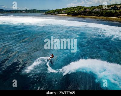 Surfista che cattura un'onda in una giornata di sole Foto Stock