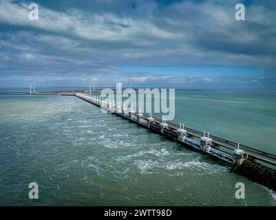 Una vista tranquilla di un lungo molo che si estende in un mare calmo sotto un cielo nuvoloso. Foto Stock