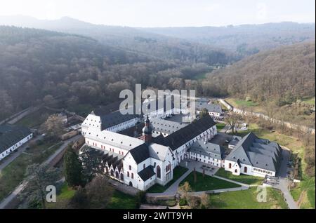 Eltville, Germania. 19 marzo 2024. La nebbia passa sopra il monastero di Eberbach (foto aerea scattata con un drone). Secondo i meteorologi, il tempo continuerà a mostrare il suo lato mutevole nei prossimi giorni. Credito: Boris Roessler/dpa/Alamy Live News Foto Stock