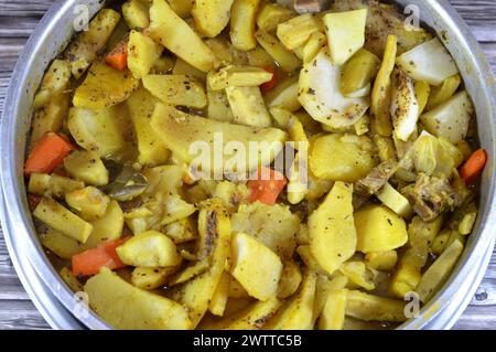 Fette di patate al forno, cipolla, carote, pezzi di carne di manzo, zucchine, spezie, aglio, paprika e alloro, patate con carne di manzo e verdure cotte al forno Foto Stock