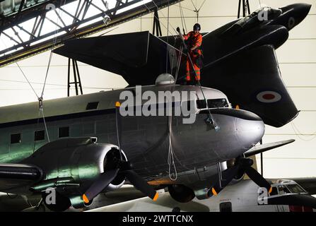 Gli specialisti dell'accesso alla fune industriale si lanciano al Royal Air Force Museum Midlands, a Cosford, vicino a Telford, nello Shropshire, per accedere a una mostra di aerei sospesi esposta nella National Cold War Exhibition, durante la pulizia e la manutenzione annuale di alto livello degli aeromobili. Data foto: Martedì 19 marzo 2024. Foto Stock