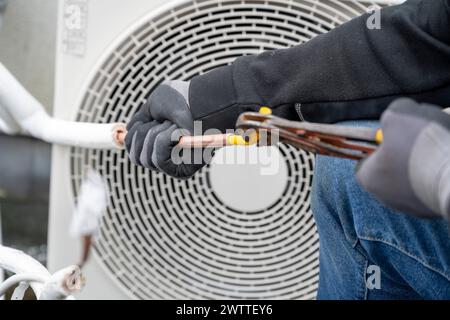Un professionista che lavora alla manutenzione HVAC. Foto Stock
