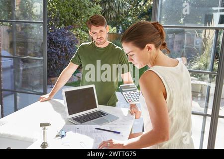 Due persone che lavorano insieme a un tavolo con un notebook Foto Stock