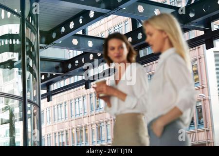 Due donne che hanno una conversazione in un ufficio moderno Foto Stock