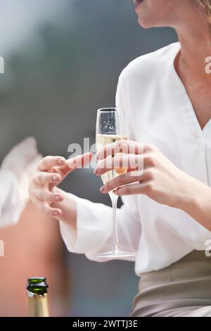 Donna che tiene un bicchiere di champagne Foto Stock