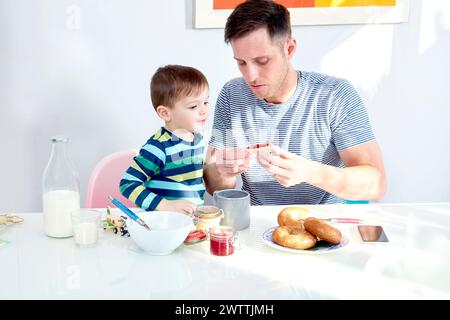 Padre e figlio si godevano la colazione insieme Foto Stock