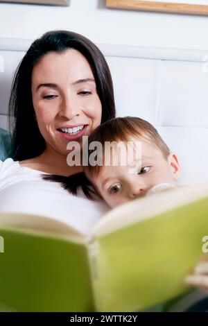 La madre e il bambino la lettura di un libro insieme Foto Stock
