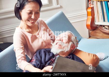 Uomo anziano che si rilassa con una donna al suo fianco Foto Stock