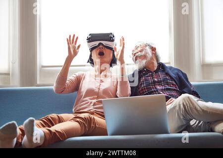 Uomo e donna senior che provano il visore per la realtà virtuale Foto Stock