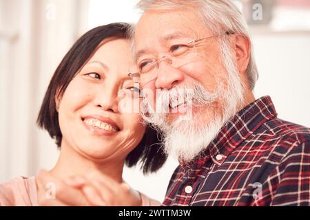 Uomo anziano sorridente e donna di mezza età che abbraccia Foto Stock
