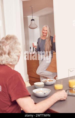Donna anziana che cucina mentre un altro osserva Foto Stock